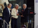 Huntsville Hamfest Association Chairman Mark Brown, N4BCD (center), receives a plaque recognizing the association’s efforts to host the 2026 ARRL National Convention. Presenting are ARRL Senior Director of Marketing and Innovation Bob Inderbitzen, NQ1R (left), and President Rick Roderick, K5UR (right).